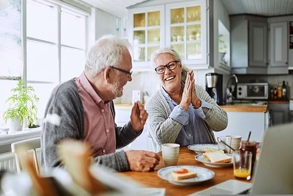 uiterst gelukkig senioren stel geniet thuis aan hun keukentafel